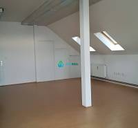 Kancelársky priestor na prenájom v Dunajskej Strede - Podkrovná kancelária s drevenou podlahou, strešnými oknami a bielymi stenami na ulici neuvedené.