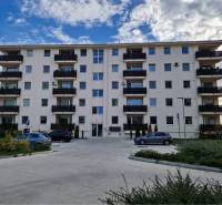 NOVOSTAVBA! Krásny, moderný a priestranný 3-izbový byt s veľkou logiou - Päťposchodová bytovka v meste Dunajská Streda na Neuvedenej ulici s parkoviskom v popredí.