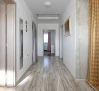 Dvojpodlažný rodinný dom s veľkým pozemkom na predaj v obci Jahodná - Chodba so svetlým dreveným obkladom, závesmi na stene Rodinného domu, na ulici neuvedená.