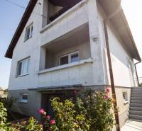 Dvojpodlažný rodinný dom s veľkým pozemkom na predaj v obci Jahodná - Rodinný dom so starším vonkajším vzhľadom, kvety na záhrade, na ulici neuvedená.