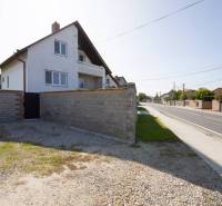 Dvojpodlažný rodinný dom s veľkým pozemkom na predaj v obci Jahodná - Rodinný dom, na ulici neuvedená, s kamenným plotom vedľa cesty a dvora.