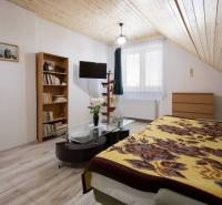 Dvojpodlažný rodinný dom s veľkým pozemkom na predaj v obci Jahodná - Podkrovná izba v Rodinnom dome s knihovňou, stolíkom a televízorom na ulici neuvedená.