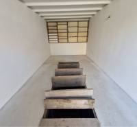 REZERVOVANÉ! Murovaná garáž - Garáže s bielymi stenami a dreveným poklopom na podlahe.