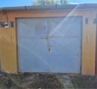 REZERVOVANÉ! Murovaná garáž - Zatvorené garážové dvere, fasáda a trávnatá plocha v Dunajskej Strede.