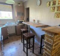 Na prenájom 3-izbový zariadený byt - Dunajská Streda - Kuchyňa v 3-izbovom byte s barovým pultom, tehlovým obložením a dekoratívnymi dlaždicami.