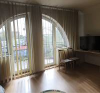 EXKLUZÍVNE LEN U NÁS! - Veľký rodinný dom - Dunajská Streda - Izba v rodinnom dome s oblúkovými oknami, vertikálnymi žalúziami a podlahou s dreveným dekorom.