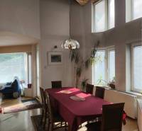 EXKLUZÍVNE LEN U NÁS! - Veľký rodinný dom - Dunajská Streda - Jedáleň v rodinnom dome s presklenými stenami, podlahou s dreveným dekorom a izbovými rastlinami.