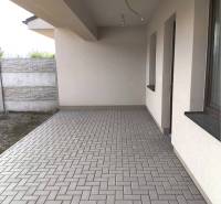 Predané - 4izbový rodinný dom (dvojdom) v obci Horná Potôň! - Vonkajšia terasa rodinného domu v Hornej Potôni s dlažbou a stenou z betónových tvárnic.