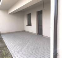 Predané - 4izbový rodinný dom (dvojdom) v obci Horná Potôň! - Terasa rodinného domu v Hornej Potôni so zámkovou dlažbou a prístreškom.