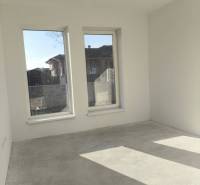 4 izbový rodinný  dom v obci Michal na Ostrove! - Rodinný dom s betónovou podlahou, bielymi stenami a veľkými oknami bez dekorácií.