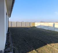 4 izbový rodinný  dom v obci Michal na Ostrove! - Pohľad na bočnú záhradu rodinného domu v Michale na Ostrove s oplotením.