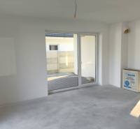 4 izbový rodinný  dom v obci Michal na Ostrove! - Izba s výhľadom na terasu, bielymi stenami a betónovou podlahou v rodinnom dome.