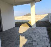 4 izbový rodinný  dom v obci Michal na Ostrove! - Terasa rodinného domu v Michale na Ostrove s dlažbou a výhľadom na dvor.