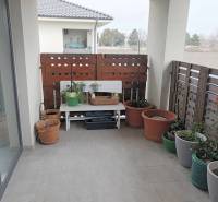 ☎️0904/842-727 Štýlové bývanie - 3izbový byt – Horný Bar - V 3-izbovom byte je balkón s kvetmi a drevenou zástenou.