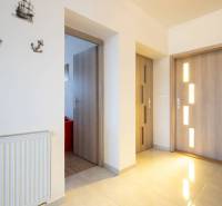 Znížená cena za 4 izbový rodinný dom v obci Jahodná - Chodba rodinného domu s drevenými dverami, radiátorom a stenovými dekoráciami.