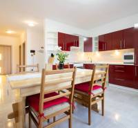 Znížená cena za 4 izbový rodinný dom v obci Jahodná - Kuchyňa s červenými skrinkami a jedálenským stolom v rodinnom dome.