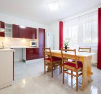 Znížená cena za 4 izbový rodinný dom v obci Jahodná - Kuchyňa so svetlým stolom, červenými skrinkami a závesmi, ideálna pre rodinný dom.