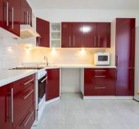 Znížená cena za 4 izbový rodinný dom v obci Jahodná - Kuchyňa v rodinnom dome s červenými skrinkami a bielymi spotrebičmi.