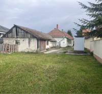 Znížená Cena!Na predaj rodinný dom vo Vrakúni, blízko Dunajskej Stredy - Zadný dvor rodinného domu vo Vrakúni s trávnikom a staršou prístavbou.