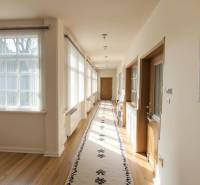 Znížená Cena!Na predaj rodinný dom vo Vrakúni, blízko Dunajskej Stredy - Interiér rodinného domu s veľkými oknami, kobercom a podlahou s dreveným dekorom.