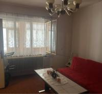 Znížená Cena!Na predaj rodinný dom vo Vrakúni, blízko Dunajskej Stredy - Obývacia izba v rodinnom dome s červenou sedačkou a otvoreným oknom.