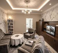 Znížená Cena!Na predaj rodinný dom vo Vrakúni, blízko Dunajskej Stredy - Obývacia izba v rodinnom dome s pohodlnými sedačkami a podlahou s dreveným dekorom.