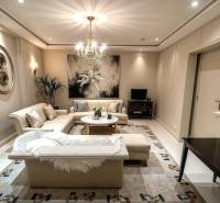 Znížená Cena!Na predaj rodinný dom vo Vrakúni, blízko Dunajskej Stredy - Obývačka v rodinnom dome s krémovým sedačkou, koberec, umelecké diela na stenách.