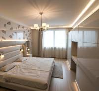 Znížená Cena!Na predaj rodinný dom vo Vrakúni, blízko Dunajskej Stredy - Svetlá spálňa v rodinnom dome s posteľou a podlahou s dreveným dekorom.