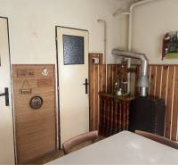 Znížená Cena!Na predaj rodinný dom vo Vrakúni, blízko Dunajskej Stredy - Interiér rodinného domu s pecou a dreveným obkladom na stene.