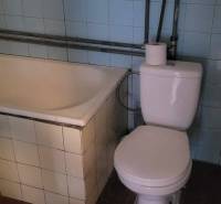 Na predaj starší rodinný dom v obci Ohrady - Kúpeľňa v rodinnom dome s vaňou, toaletou a modrými obkladačkami.