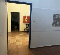 Exkluzívny obchodný priestor na predaj v centre Dunajskej Stredy – ul. - Interiér obchodných priestorov s kachličkami, podlahou s dreveným dekorom a skladacími stoličkami.