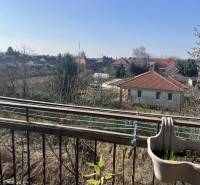 Štartovací 2-izbový byt s balkónom a klimatizáciou – Ohrady - Výhľad z 2-izbového bytu v Ohradách s pohľadom na susedné domy a záhrady.