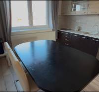 Prenájom 2-izbového bytu, Dunajská Streda - Kuchynský kút v 2-izbovom byte s jedálenským stolom a podlahou s dreveným dekorom.