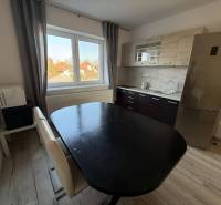 Prenájom 2-izbového bytu, Dunajská Streda - Kuchyňa v 2-izbovom byte s drezom, chladničkou a podlahou s dreveným dekorom.