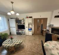 Predaj rodinného domu, Dunajská Streda - Obývacia izba v rodinnom dome s televízorom, krbom a jedálenským stolom.