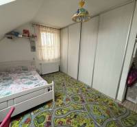 Predaj rodinného domu, Dunajská Streda - Detská izba v rodinnom dome s kobercem a bielou posteľou.