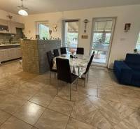 Predaj rodinného domu, Dunajská Streda - Jedáleň v rodinnom dome so stolom, kuchynskou linkou a obývačkou so sedačkou.