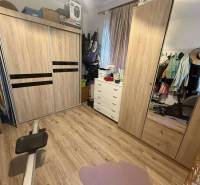 Predaj rodinného domu, Dunajská Streda - Šatník v rodinnom dome s podlahou s dreveným dekorom, šatníkovými skriňami a komodou.