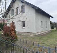 Predaj rodinného domu, Dunajská Streda - Rodinný dom v Dolnom Štále so sivou fasádou, záhrada, plot a stromy.