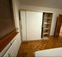 Prenájom 3-izbového bytu, Dunajská Streda - Spálňa v 3-izbovom byte s podlahou s dreveným dekorom a šatníkovou skriňou.