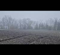 Pozemok-Bohelov - Hmlistá panoráma Zvláštnych nehnuteľností v Boheľove s rozoraným poľom a stromami na obzore.