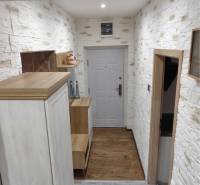 ☎️ 0918197701-Predám 3 izbový byt s loggiou po kompletnej rekonštrukci - Chodba s bielou tehlovou stenou a podlahou s dreveným dekorom v 3-izbovom byte.