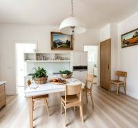 ☎️ 0918197701- Na predaj starší rodinný dom vhodný na kompletnú presta - Kuchyňa v rodinnom dome s podlahou s dreveným dekorom, bielym nábytkom a obrazmi.