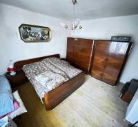 ☎️ 0918197701- Na predaj starší rodinný dom vhodný na kompletnú presta - Spálňa v rodinnom dome s dreveným dekorom, posteľou, skriňami a stropným svietidlom.