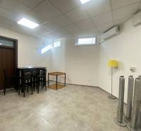 ☎️ 0918197701-Na prenájom väčší obchodný priestor 230 m² v suteréne v  - Interiér obchodných priestorov so stolíkom, stoličkami, žltou lampou a klimatizáciou.