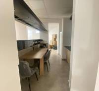 ☎️ 0918197701-Na prenájom väčší obchodný priestor 230 m² v suteréne v  - Interiér obchodných priestorov s dlhým stolom a stoličkami, biele steny, svetlá dlažba.