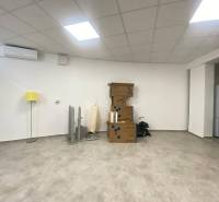 ☎️ 0918197701-Na prenájom väčší obchodný priestor 230 m² v suteréne v  - Interiér obchodných priestorov s krabicami, žltou lampou a podlahou s dreveným dekorom.