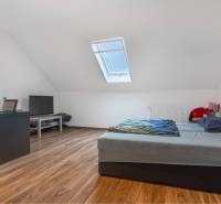 ☎️ 0918197701-Na predaj 5 izbový poschodový rodinný dom s 2 garážou v  - Podkrovná spálňa s posteľou, TV a podlahou s dreveným dekorom v rodinnom dome.