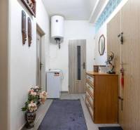 ☎️ 0918197701- PREDAJ - Nebytových priestorov Dunajská Streda - Interiér s drevenými dekoráciami, zrkadlom a komodou, vybavený dekoratívnym kvetom a bojlerom.