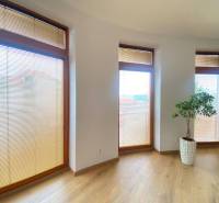 ☎️ 0918197701   Na predaj  elegantný 3 izbový byt priamo v centre Duna - Svetlá izba s tromi vysokými oknami a podlahou s dreveným dekorom v 3-izbovom byte.